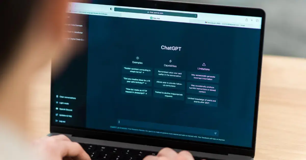 Mężczyzna siedzący przed laptopem, z włączonym Chatem GPT