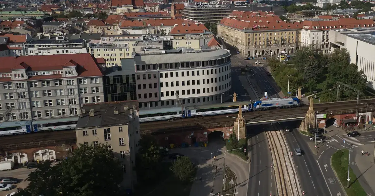 Pociąg PKP Intercity jadące po torach w mieście