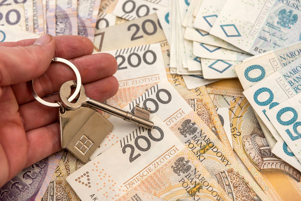 Zdjęcie przedstawia polskie banknoty i klucz do mieszkania.