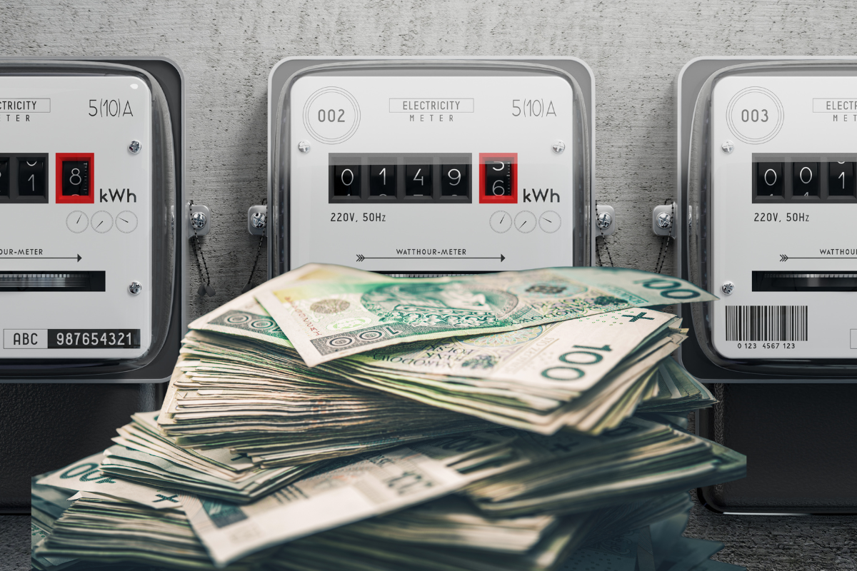Zdjęcie przedstawia liczniki prądu i stos pieniędzy.