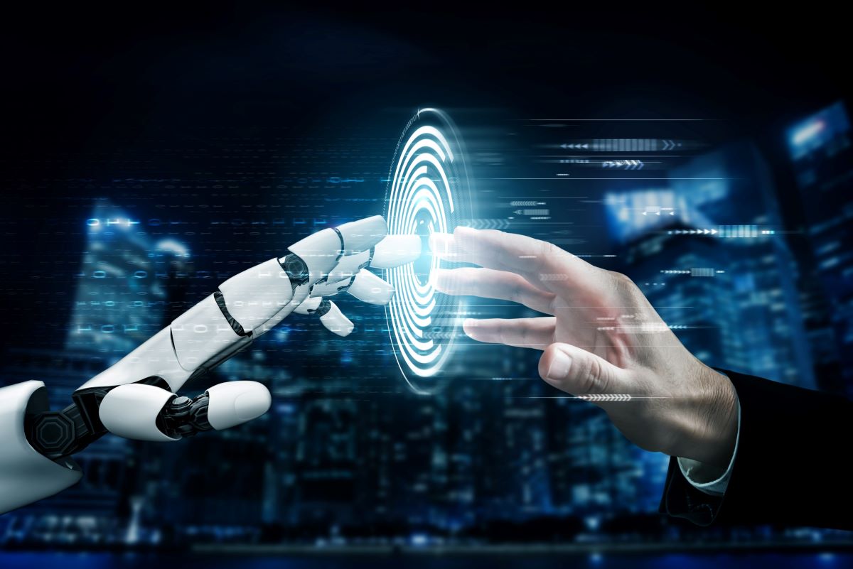 Zdjęcie przedstawia dłoń robota i dłoń biznesmena na tle miasta.