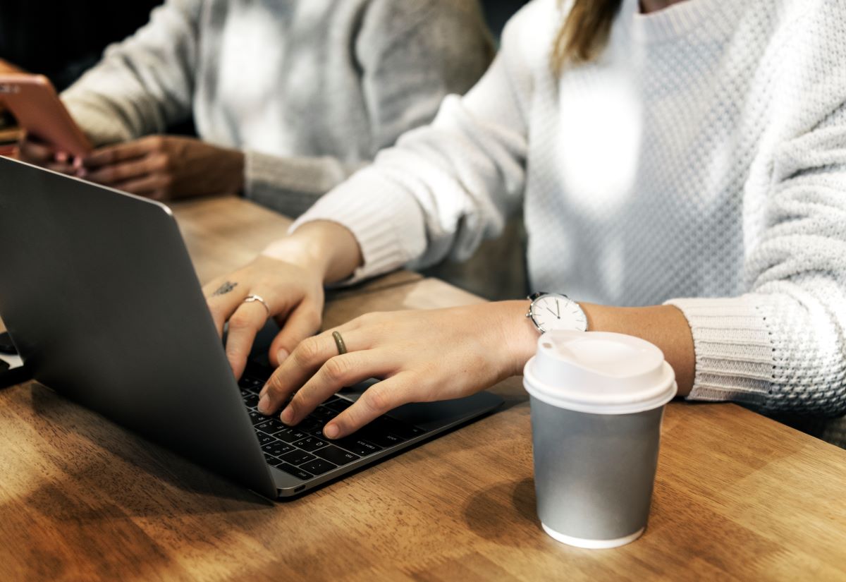 Zdjęcie przedstawia kobietę pracują przy laptopie.